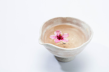 Pink flowers in a white ceramic bowl. plum blossom on it 