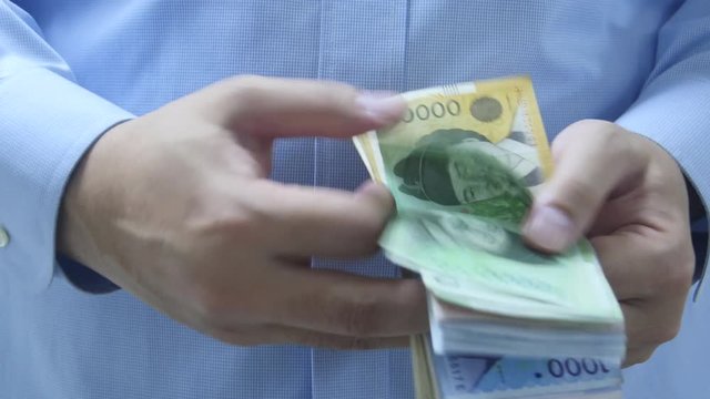 Man counting korean money in hands