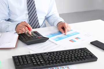 Businessman sitting on desk and writing a paper