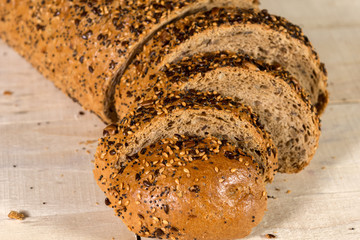 Fresh bread slice with sunflower seeds on wooden table and Wheat
