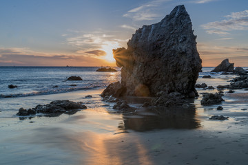 Sunset behind a sea rock at El Matador Beach near Malibu California