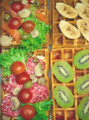 Belgian waffles with salami, green salad, tomatoes, champignon mushrooms, olives and kiwi. Breakfast, selective focus