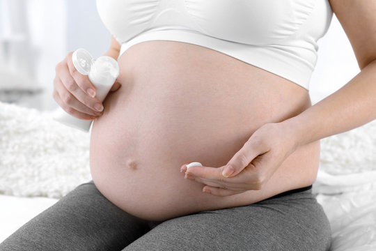 Closeup of pregnant woman with nourishing cream