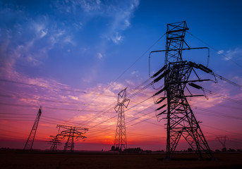 The silhouette of the evening electricity transmission pylon