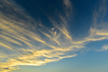Naklejka na ściany i meble Fluffy clouds with sunlight effect on blue sky before sunset