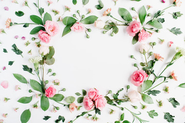 Round frame made of pink and beige roses, green leaves, branches, floral pattern on white background. Flat lay, top view. Valentine's background