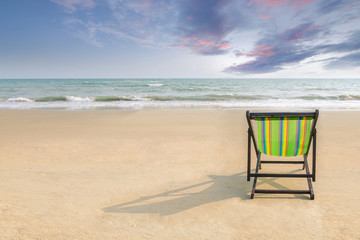 Beach chair and shadow on the white sand beach with sunset light