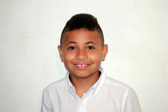 Young Biracial Boy Smiling On White Background