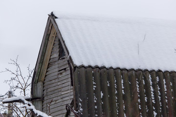 Snow on the roof of the house in the winter