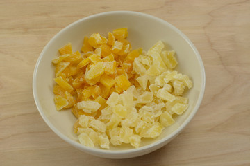 Chopped dried mango and pineapple pieces in white bowl