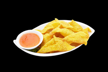 Crispy wonton with chili sauce isolated on black background.