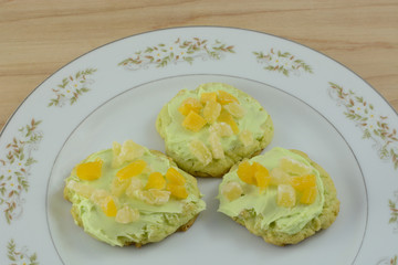 Three frosted key lime sugar cookies on plate
