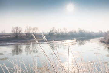 Winter scenery, with frozen river and frost cover vegetation on a cold, sunny, day