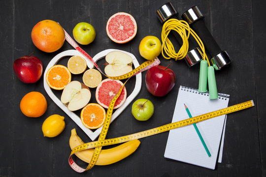 Diet plan, fruits and centimeter on a black background