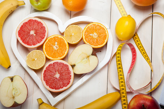 Fruits in heart and centimeter on a white background