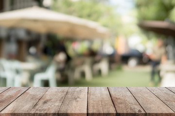 Wood table top and blurred restaurant exterior background - can used for display or montage your...