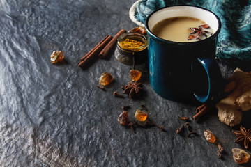 Traditional Indian masala tea in ceramic cup with spices to milk - obrazy, fototapety, plakaty