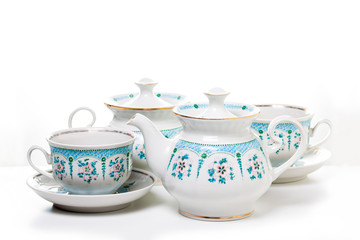 Ornamental  vintage tea set, Kettle, sugar bowl , cups and  saucers.  Decorative background