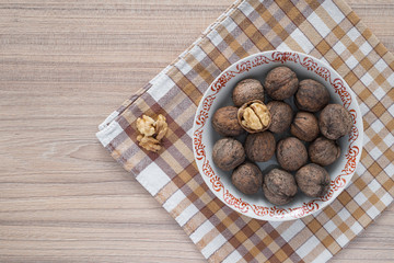 Whole walnuts and walnut kernels on table from above