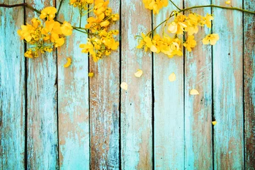 Poster Gele bloemen op vintage houten achtergrond, boordmotief. vintage kleurtoon - concept bloem van lente of zomer achtergrond © jakkapan