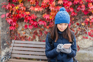 Woman using cellphone with maple tree background