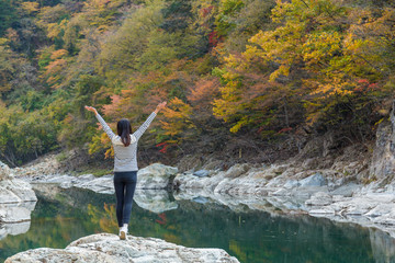 Excited woman raising up hand in forest