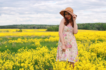 girl in a field of flowers with basket and a hat