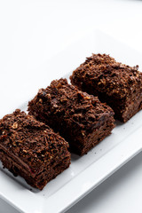 French Chocolate Napoleon cake of puff pastry with sour cream on a white plate close-up. Nutritious dessert. Selected Focus
