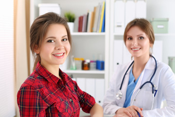 Smiling female patient sitting at medicine doctor office