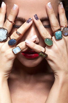 Young woman  with  with many bijouterie rings with stones on fin