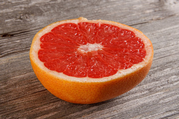 Fototapeta na wymiar Half of grapefruit on gray board/Close up of sliced grapefruit