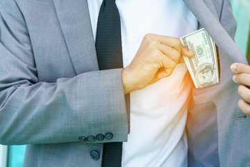 Businessman pulling money from his pocket suit