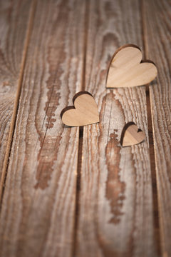 Different size heart figures on wooden background 