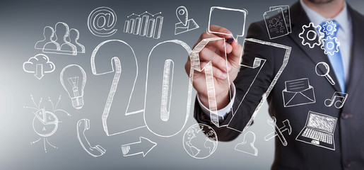 Businessman touching 2017 hand drawn text