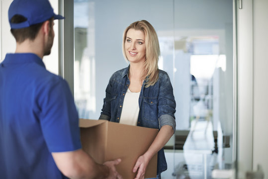 Woman getting a parcel from delivery man