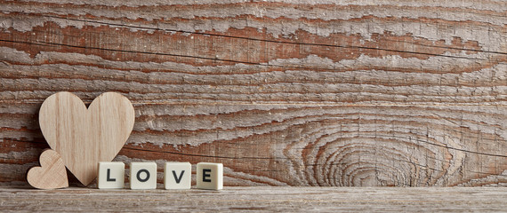 Love write on wooden background with heart figure