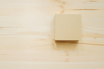 Paper box on the wood desk texture in daylight