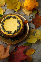 Delicious pumkin cake with leaves on background.