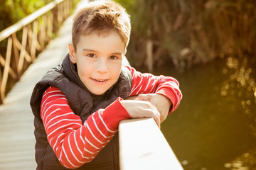 Smiling boy on a wooden bridge looking at the camera