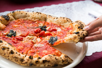 Woman taking out a sliced of pizza
