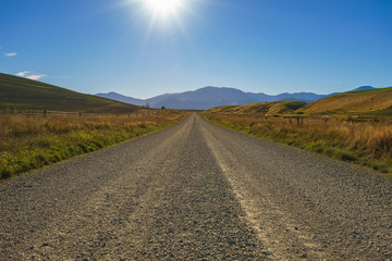 Rural Gravel Road with Hilly Green Pasture on both side. Canterb