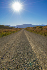 Rural Gravel Road with Hilly Green Pasture on both side. Canterb