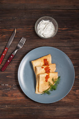 Pancakes with red caviar on plate. Russian cuisine.
