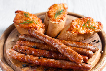 Catering platter with grilled sausages and canapes. Set of roasted fat snacks for beer on wooden board. Junk food, dieting, restaurant menu concept