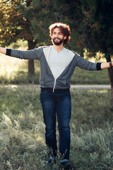 Happy man hugging world, full-length photo. Smiling guy in casual clothes standing with widely spaced hands. Life love, joy, pleasure, relax, happiness concept