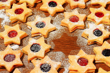 Christmas cookies in the shape of a star sprinkled with sugar on a brown wooden background