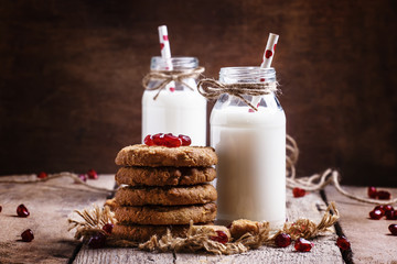 Milk beverages in glass bottles, crisp cookies with pomegranate