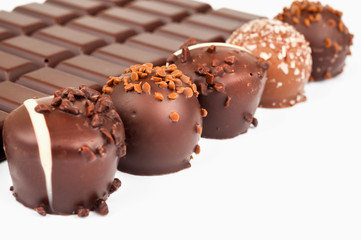 Row of chocolate truffles on white background