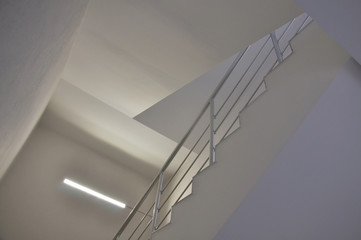 Detail of white modern staircase with metal guardrail. Look up.