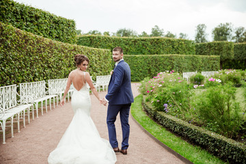 Young wedding couple walking together at park.